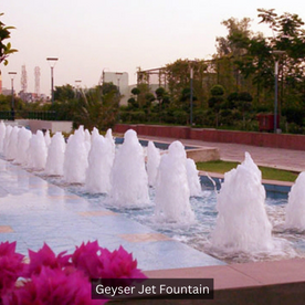 A beautiful water fountain surrounded by greenery with showcasing vibrant water jets